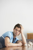 Photo: Frustrated Man sitting at conference table With Crumpled Paper looking over shoulder, side view Frustrated Man sitting at conference table With Crumpled Paper looking over shoulder, side view