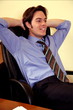 Young businessman relaxing with hands behind head
