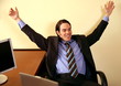 Young businessman smiling and raising arms in excitement