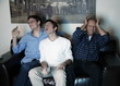 Three men watching a game on television