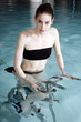 Young woman on exercise bike in spa pool