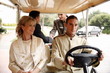 Couple being driven in cart by hotel bellboy