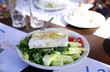 Oil being poured on Greek salad