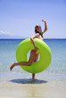 Young woman on beach with inflatable life ring