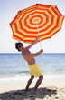 Man on beach with beach umbrella