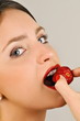 Female young adult eating a strawberry