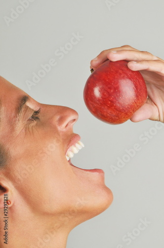 Photo: Female adult eating an apple Female adult eating an apple