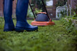 A man cutting the grass with a lawnmower