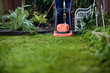 A man cutting the grass with a lawnmower