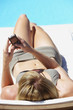 Rear view of woman sunbathing on folding chair with blackberry
