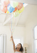 Girl with balloons looking up smiling