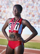 Athlete standing proudly with three medals around neck