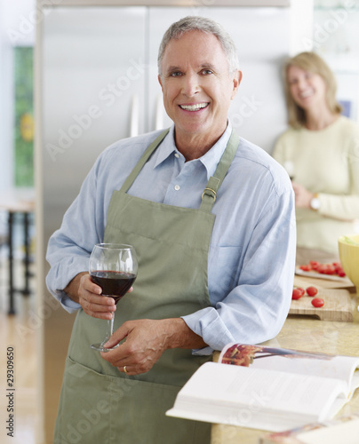 Photo: Couple in kitchen preparing meal and drinking wine Couple in kitchen preparing meal and drinking wine