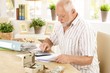 Senior man doing calculation at home Senior man doing calculation at home