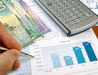 Male hand with pen on the investment chart with dollars Male hand with pen on the investment chart with dollars