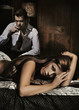 Sexy young woman laying on the bad and man drinking wine