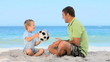 Boy and his father playing with a soccer ball