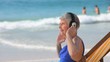 Aged woman listening to music on the beach
