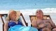 Elderly couple relaxing on beach chairs