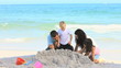 Joyful family building a sand castle