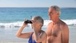 Elderly couple looking through binoculars