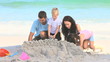 Happy family building a sand castle