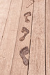 Empreintes de pied mouillé sur une terrasse en bois