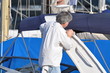 homme debout qui nettoie son bâteau au port