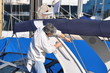 homme debout qui nettoie son bâteau au port