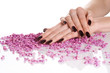 Hands with dark manicure lying down on stones Hands with dark manicure lying down on stones