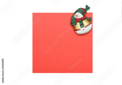 Photo: Snowman refrigerator magnet on a paper sheet Snowman refrigerator magnet on a paper sheet