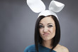 Funny Brunette in a bright sweater with rabbit ears on her head.
