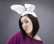 Funny Brunette in a bright sweater with rabbit ears on her head.
