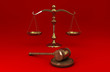 Golden scale and gavel on red solid background