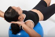 Fitness workout by young woman using exercise ball