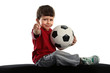 Child sits with soccer ball and shows the finger OK Child sits with soccer ball and shows the finger OK