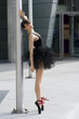 ballerina in black tutu near a pole