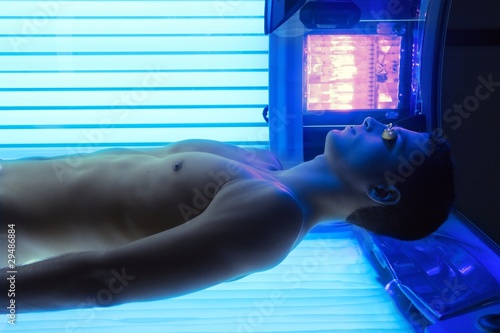 Photo: Tanning solarium young man laying Tanning solarium young man laying