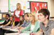 Photo: Teenage Students Studying In Classroom With Teacher Teenage Students Studying In Classroom With Teacher