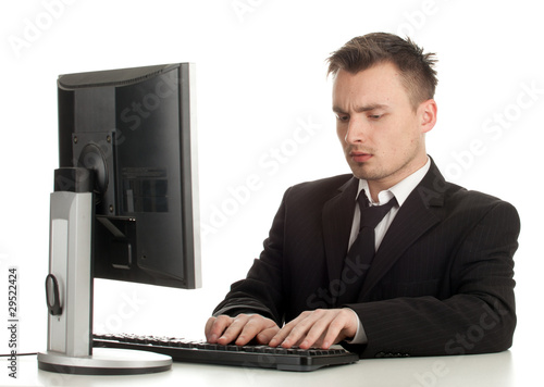 Photo: young man in black suit working on computer young man in black suit working on computer