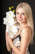 Young beautiful girl with orchid on black background
