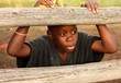 Boy on rail fence on farm