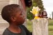 Boy looks at gloves on fence post