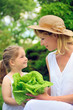 Young mother and daughter with lettuce