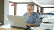 Senior man working at home on laptop computer