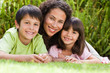 Joyful family lying down in the garden at home