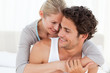 Photo: Lovely couple hugging on their bed Lovely couple hugging on their bed
