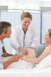 Photo: Pregnant woman with her husband listening to the nurse Pregnant woman with her husband listening to the nurse