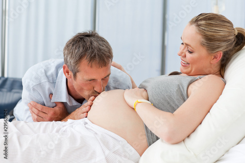 Photo: Man kissing his wife's belly Man kissing his wife's belly