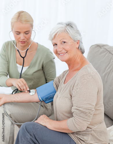 Photo: Lovely doctor taking the blood pressure of her patient Lovely doctor taking the blood pressure of her patient